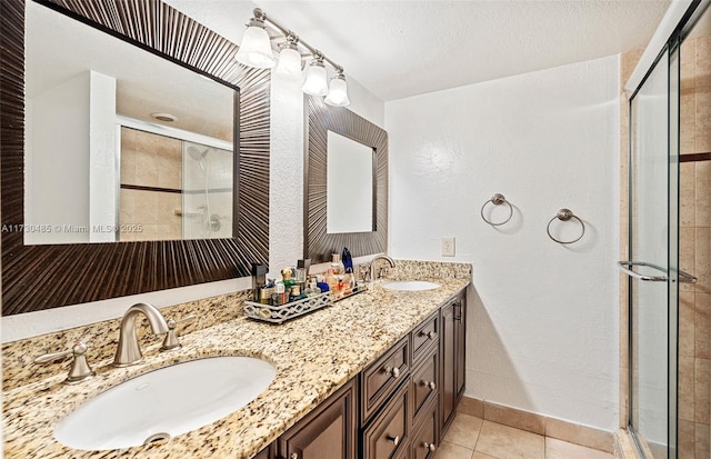 bathroom featuring tile patterned floors, a shower with shower door, and vanity