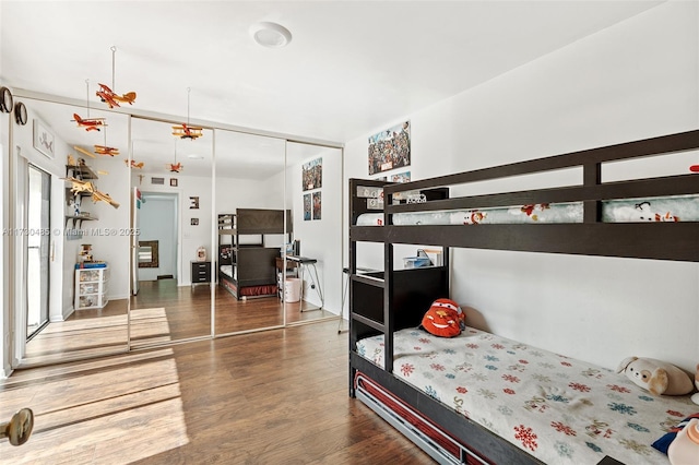 bedroom with dark hardwood / wood-style flooring and a closet