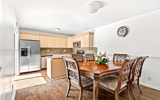 dining room featuring sink, ornamental molding, and light wood-type flooring