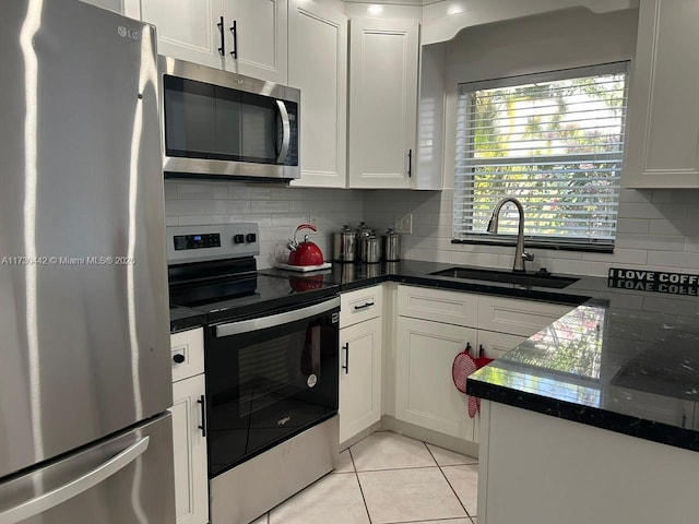 10781 NW 12th Dr, Plantation, FL 33322 - kitchen featuring stainless steel appliances, decorative backsplash, white cabinetry, light tile patterned flooring, and dark stone countertops