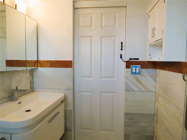 bathroom with vanity and tile walls