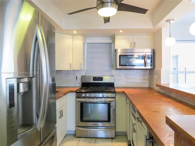 kitchen featuring white cabinetry, stainless steel appliances, and wooden counters