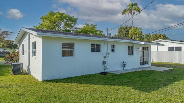 rear view of property featuring central AC and a yard