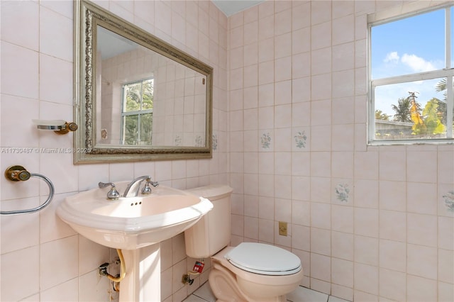 bathroom with tile walls and toilet