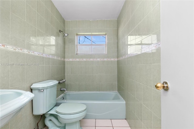 bathroom with tiled shower / bath, tile walls, tile patterned floors, and toilet