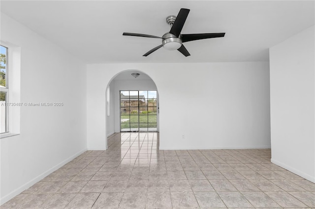 tiled spare room with ceiling fan