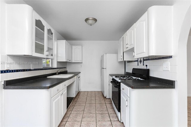 kitchen with backsplash, white cabinetry, light tile patterned floors, and black gas range oven