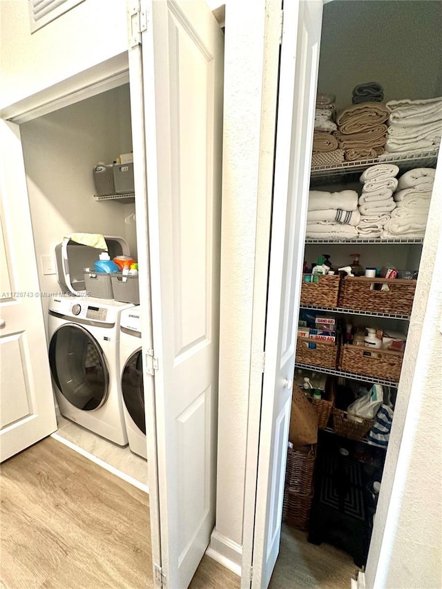 washroom with wood-type flooring and separate washer and dryer