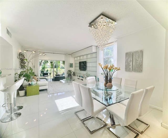 dining room featuring light tile patterned flooring, a chandelier, and a textured ceiling