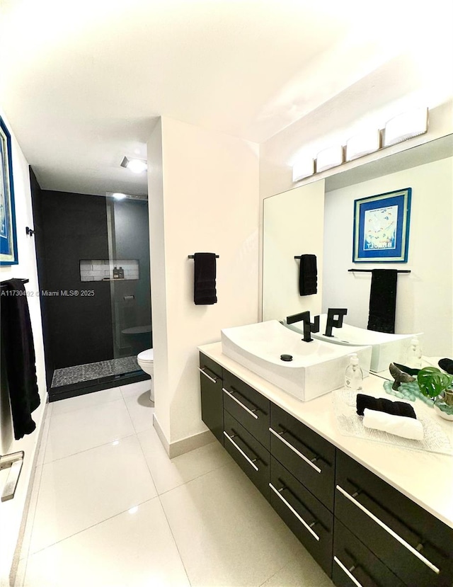 bathroom featuring tile patterned flooring, vanity, a shower, and toilet