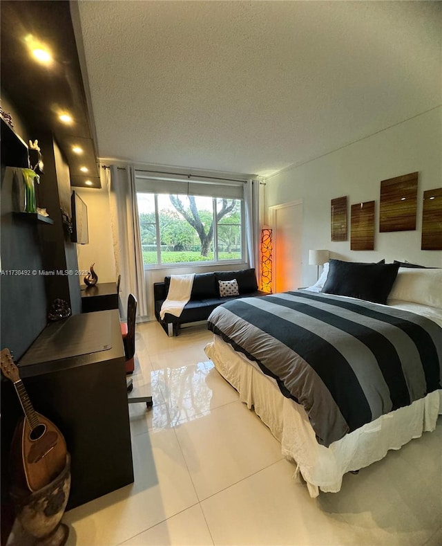 bedroom with light tile patterned flooring and a textured ceiling