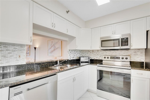 kitchen featuring sink, white cabinets, decorative backsplash, and stainless steel appliances