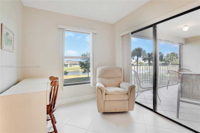 living area with plenty of natural light, light tile patterned floors, and a water view