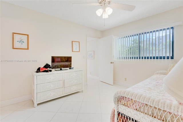 tiled bedroom featuring ceiling fan and a textured ceiling