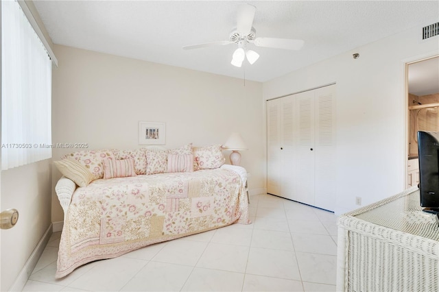 tiled bedroom featuring a closet and ceiling fan