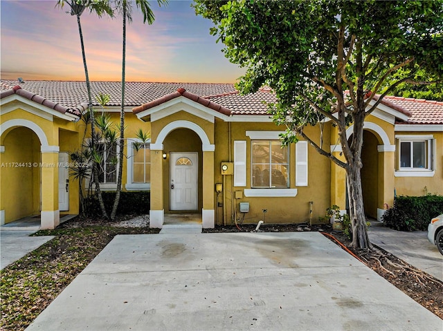 mediterranean / spanish-style home with stucco siding and a tiled roof