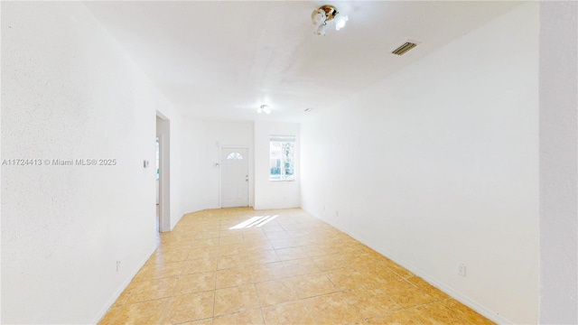 unfurnished room featuring light tile patterned flooring and visible vents