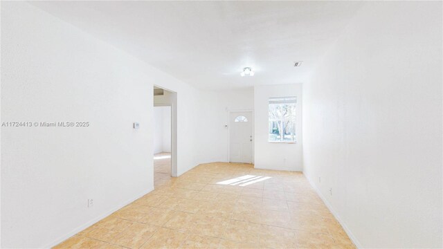 hall featuring sink and light tile patterned floors