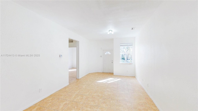 spare room featuring light tile patterned floors and visible vents