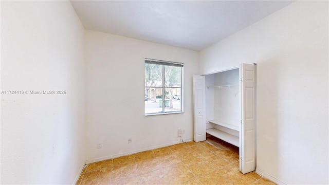 unfurnished bedroom featuring a closet and baseboards