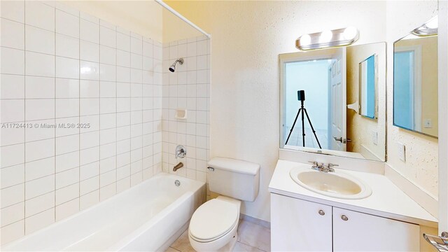 full bathroom featuring tiled shower / bath combo, vanity, and toilet