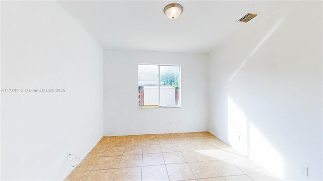 unfurnished room with light tile patterned flooring and visible vents