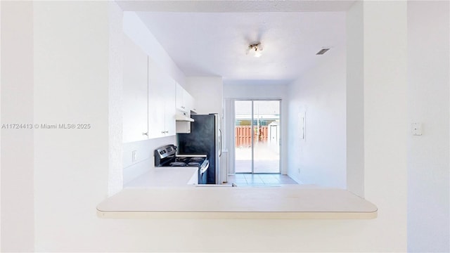 kitchen featuring electric range, visible vents, under cabinet range hood, white cabinetry, and light countertops