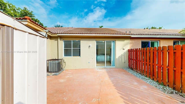 back of house featuring a patio, fence, central AC, stucco siding, and a tile roof