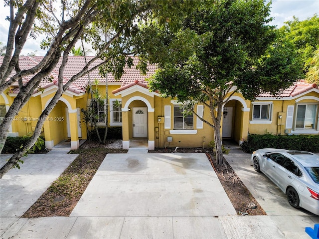 view of front facade featuring a tiled roof and stucco siding