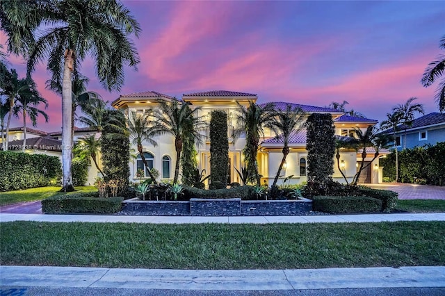 mediterranean / spanish house featuring a lawn