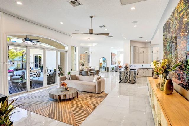 living room with a textured ceiling, a towering ceiling, ceiling fan, and french doors