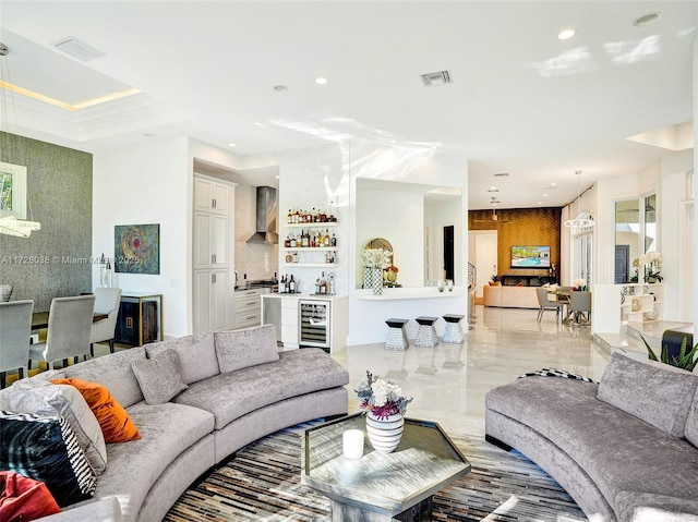 living room with indoor bar, beverage cooler, and ornamental molding