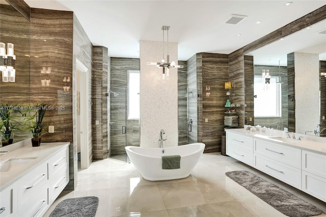 bathroom with independent shower and bath, tile walls, an inviting chandelier, and vanity