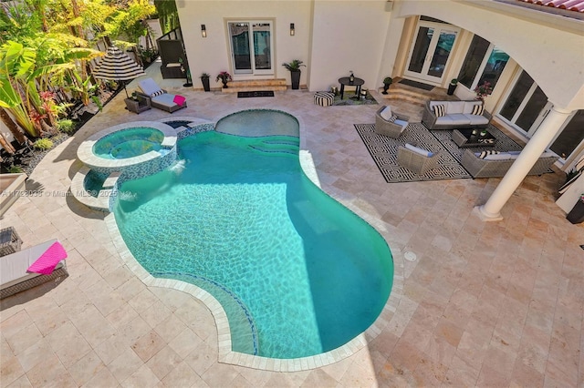 view of swimming pool with an in ground hot tub, a patio area, and french doors