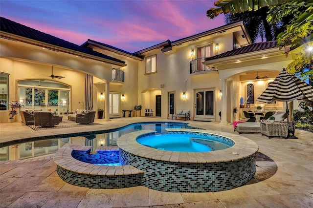 pool at dusk with an outdoor living space, an in ground hot tub, a patio area, and ceiling fan