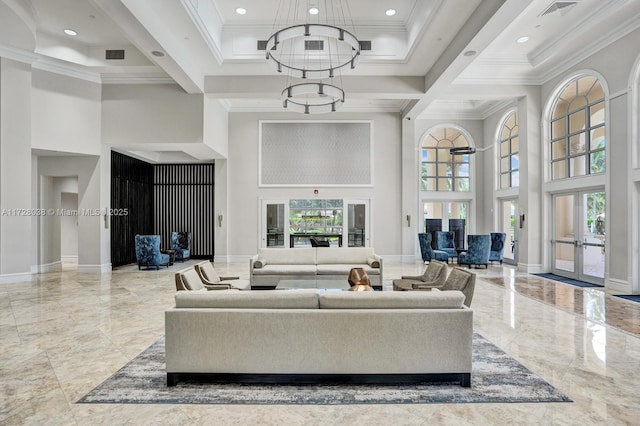 living room featuring ornamental molding, a chandelier, a towering ceiling, and french doors