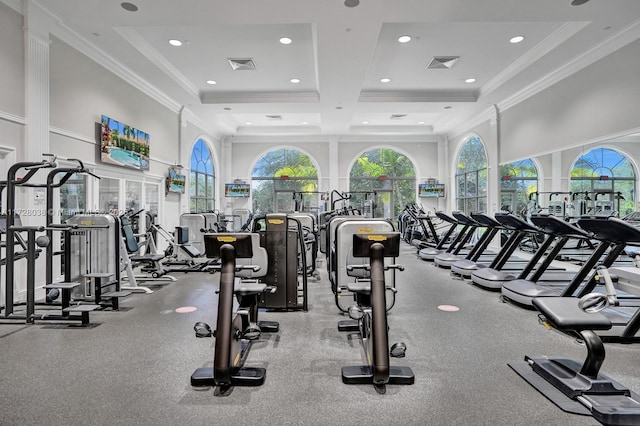 gym featuring crown molding, a towering ceiling, and coffered ceiling