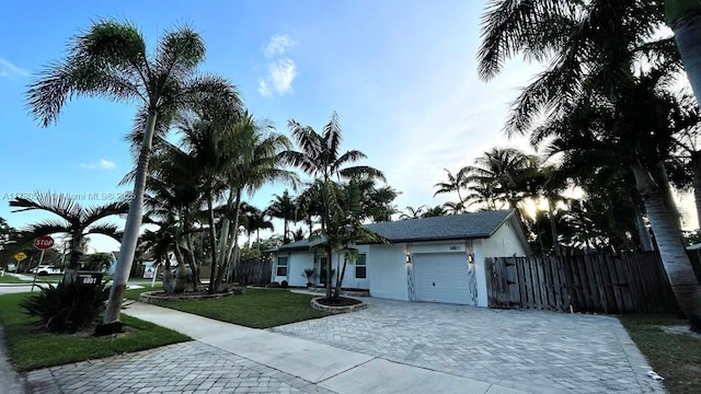 single story home with a garage and a front lawn