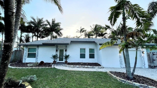 ranch-style home with a garage and a front lawn