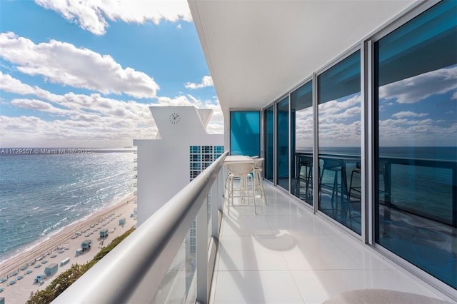 balcony featuring a water view and a view of the beach