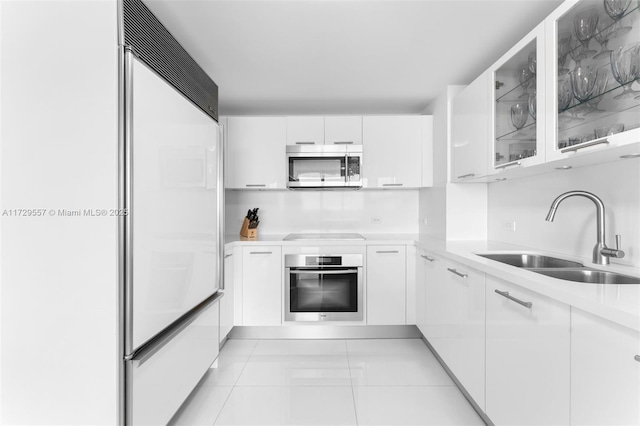 kitchen with sink, light tile patterned floors, white cabinets, and appliances with stainless steel finishes