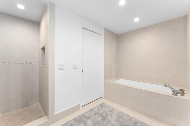 bathroom featuring a relaxing tiled tub