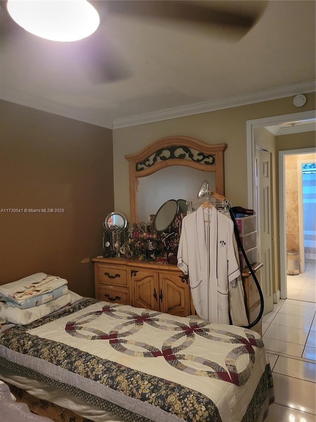 bedroom featuring ornamental molding, light tile patterned floors, and ensuite bath