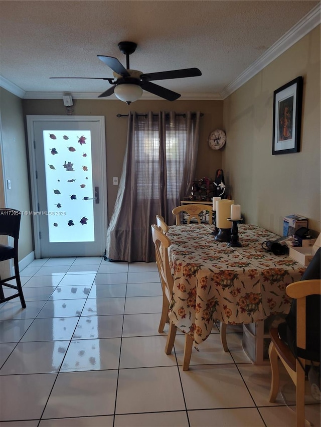 tiled dining area with ceiling fan, a textured ceiling, and crown molding