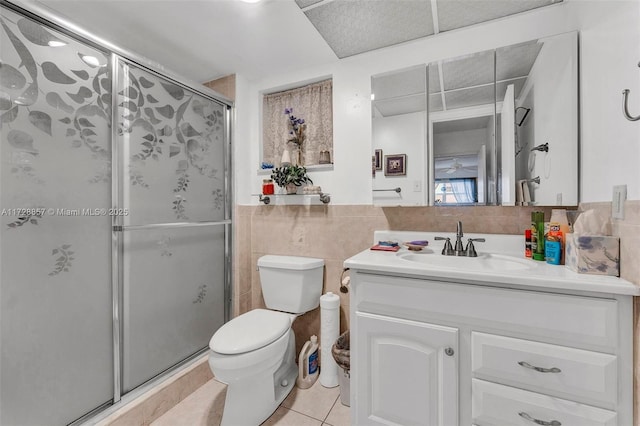 bathroom featuring a shower with door, toilet, vanity, and tile patterned flooring