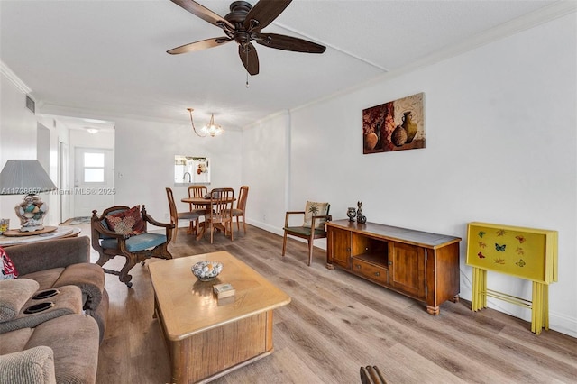 living room featuring light wood-type flooring, ceiling fan with notable chandelier, and ornamental molding