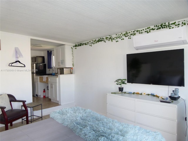 bedroom featuring an AC wall unit and stainless steel refrigerator