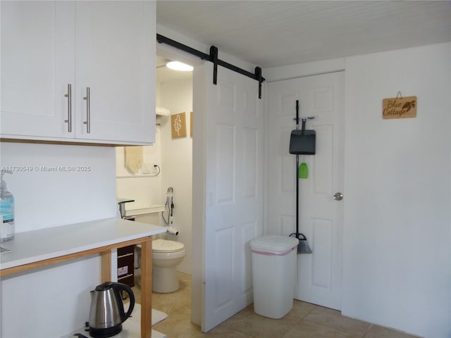 bathroom with toilet and tile patterned flooring