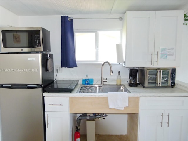 kitchen with appliances with stainless steel finishes and white cabinets