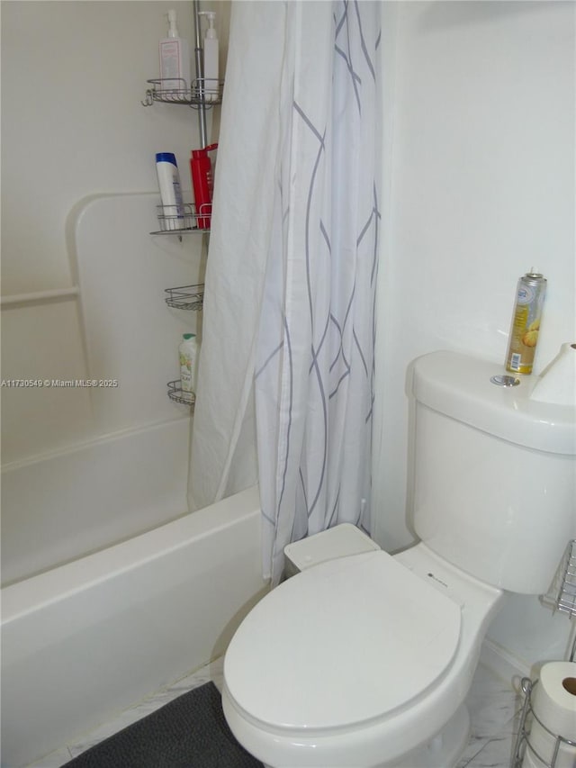 bathroom with toilet and shower / bath combo with shower curtain